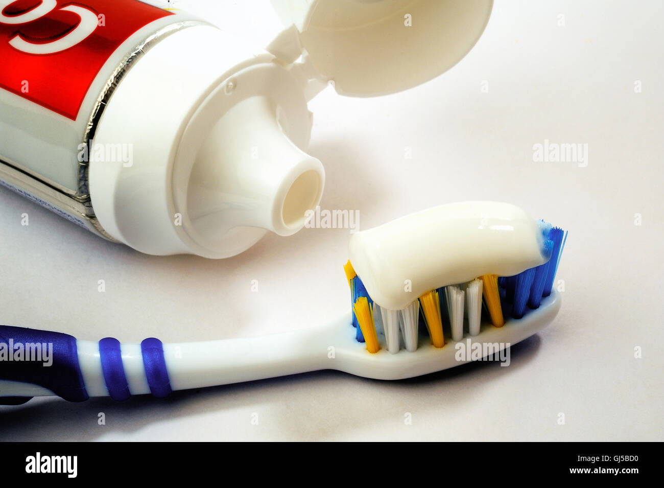 Entire tube of toothpaste with a toothbrush close-up on white ...