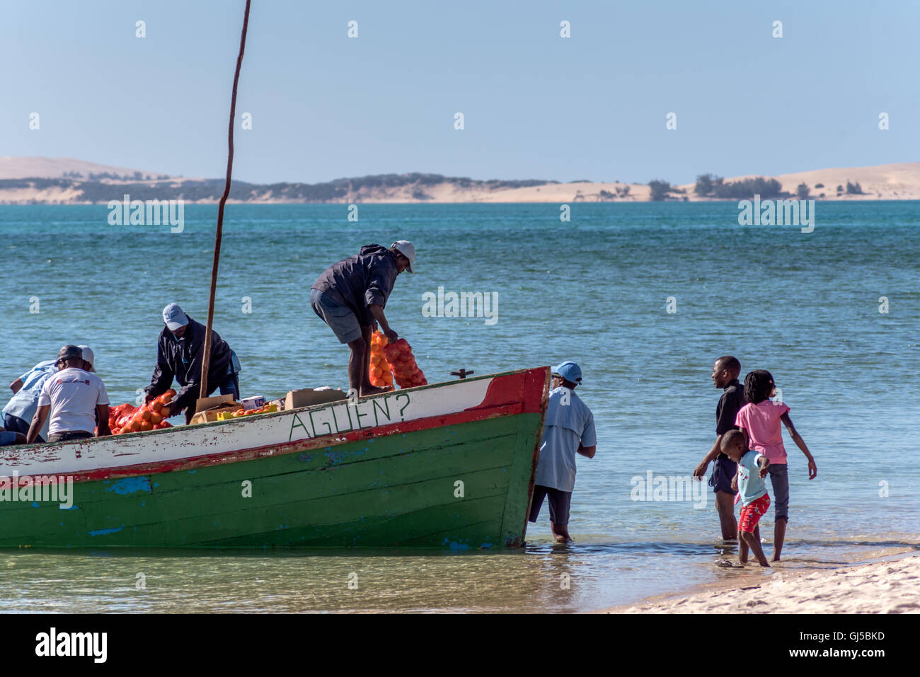 Locals unloading a dhow with provisions on the beach at Benguerra island Mozambique Stock Photo