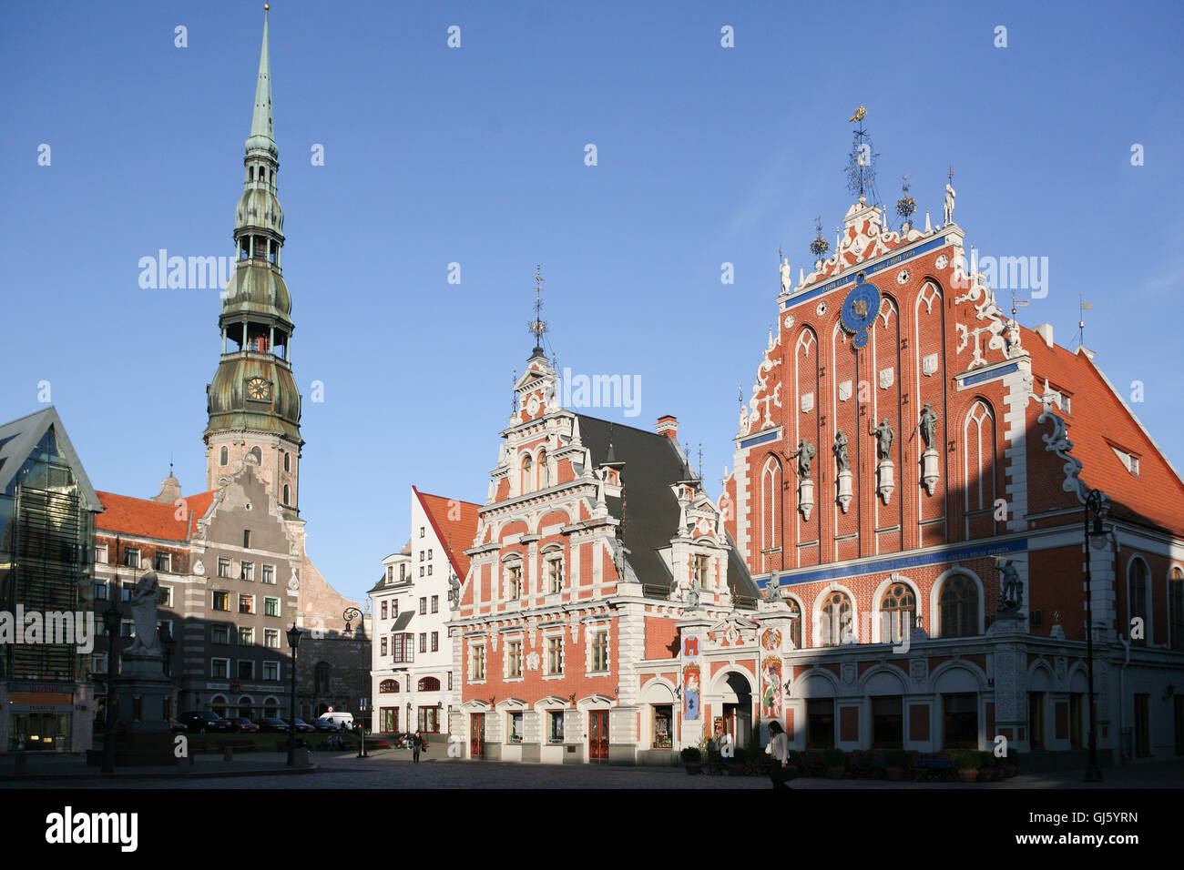 The famous Hanseatic House of Blackheads, originally built in 1344, and rebuilt in 1999 after being destroyed in WWII, in the Old Town, in the centre of Riga, the capital of Latvia. Spire of St Peter's Church on left. May. Stock Photo