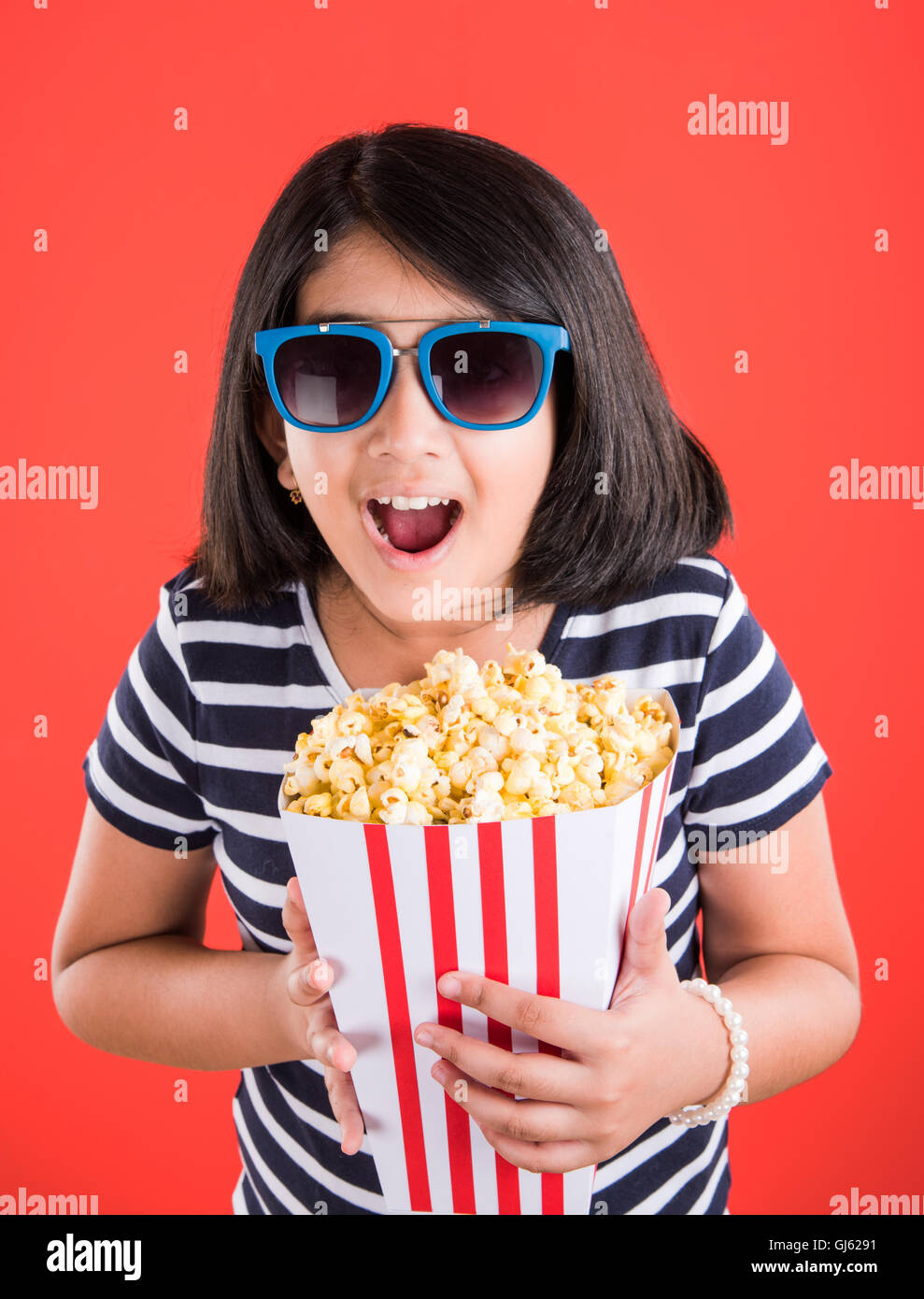 happy girl eating popcorn, indian girl eating popcorn, asian girl and