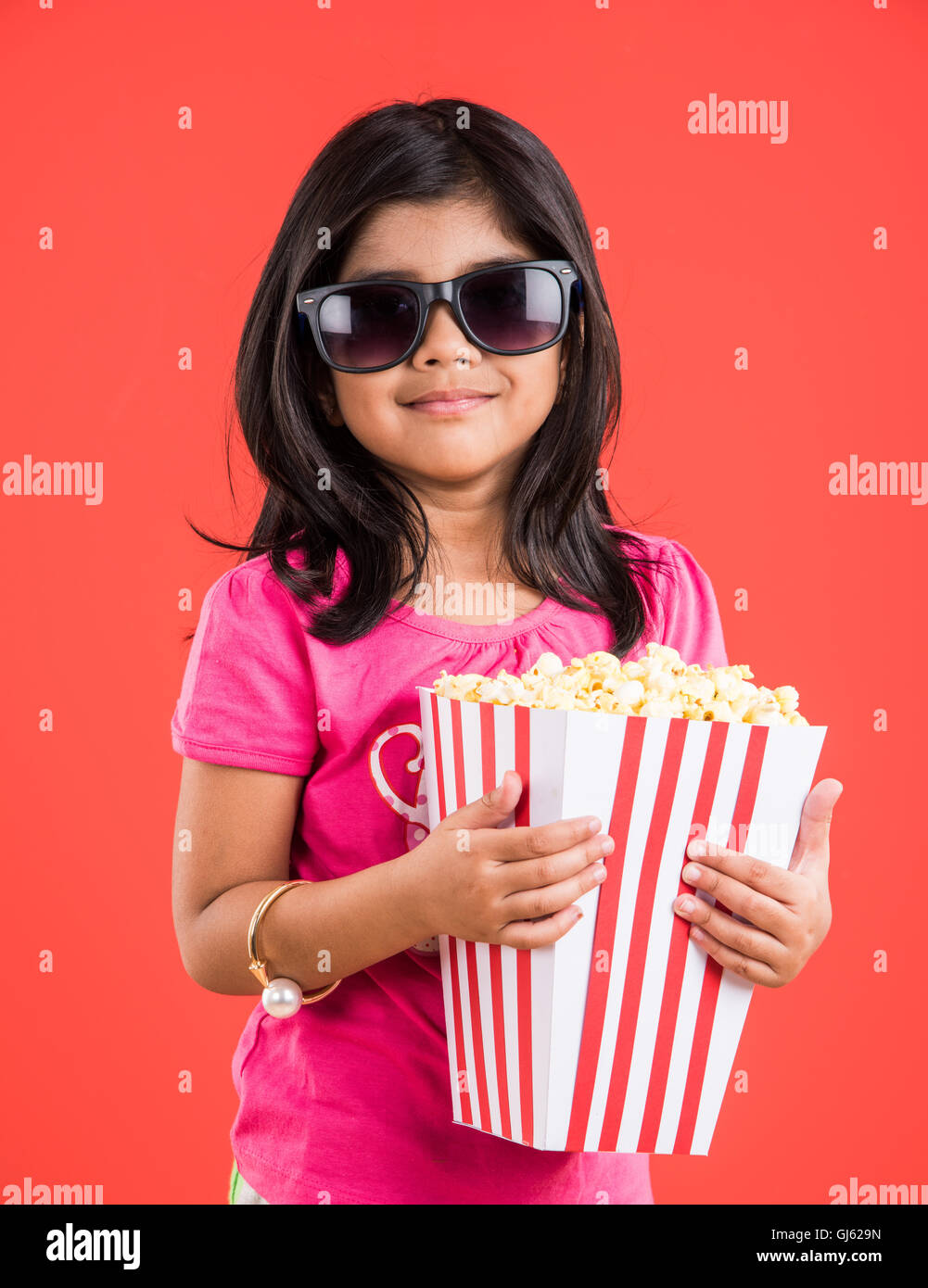 happy girl eating popcorn, indian girl eating popcorn, asian girl and