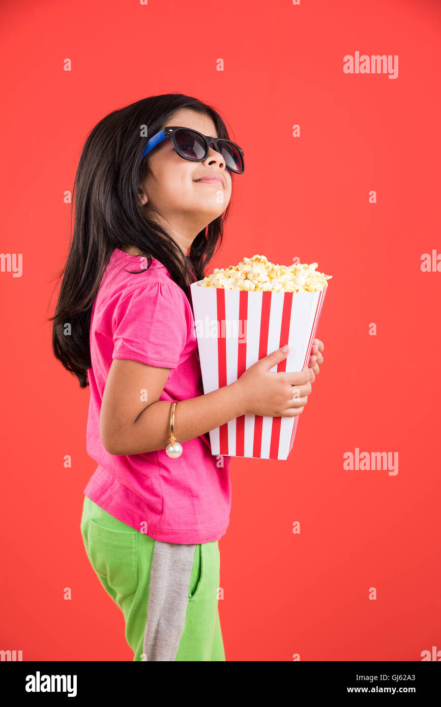 happy girl eating popcorn, indian girl eating popcorn, asian girl and