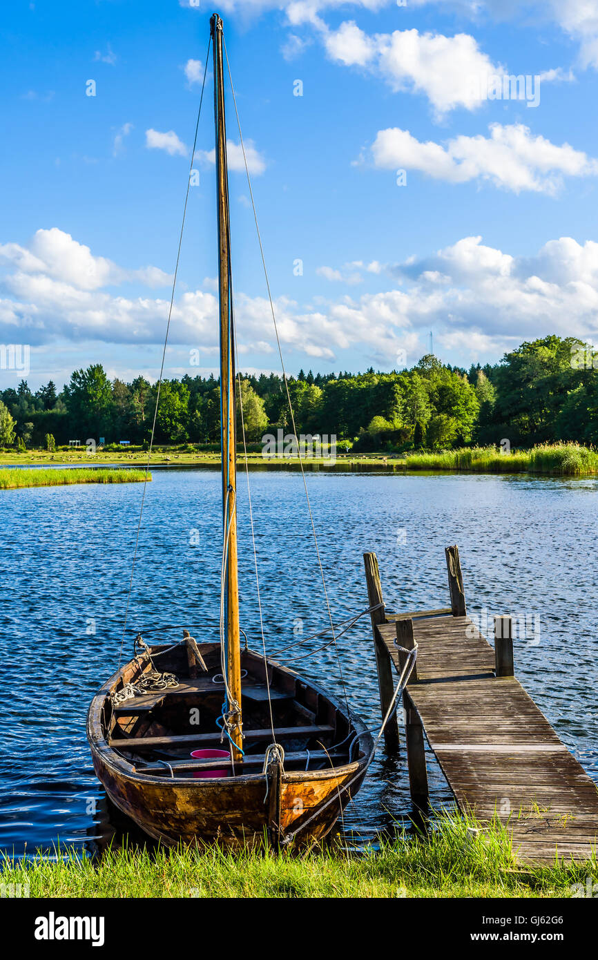 Pataholm, Sweden - August 9, 2016: Traditional wooden skiff with mast moored at small pier in the archipelago. Stock Photo