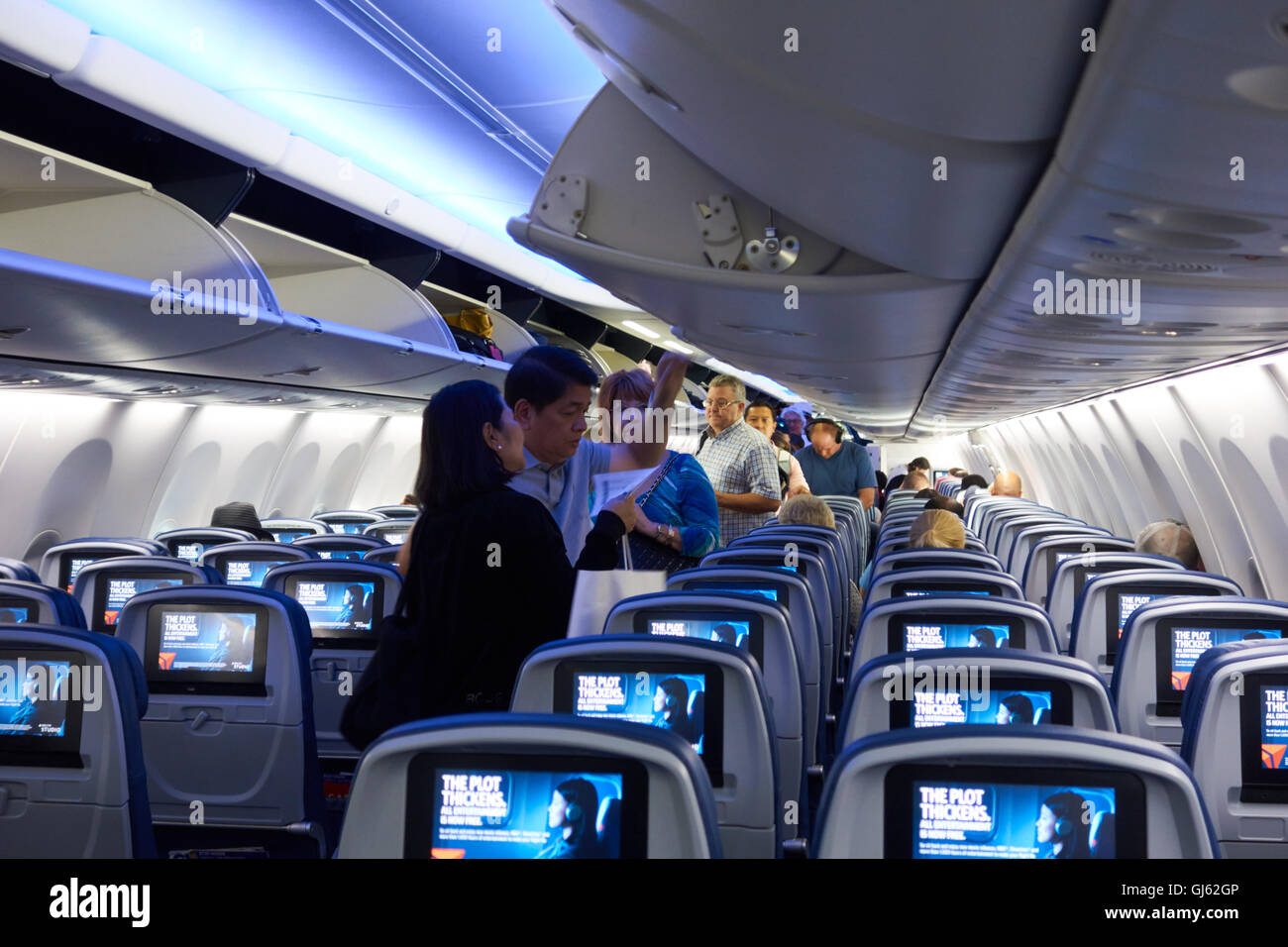 inside of airliner with passengers boarding. USA Stock Photo