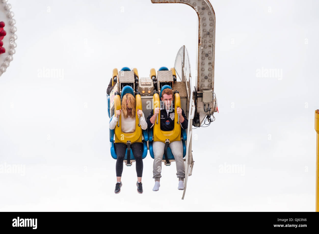 Couple making funny facial expressions riding the Booster roller coaster on the Brighton pier, Brighton, UK as of 2012 Stock Photo