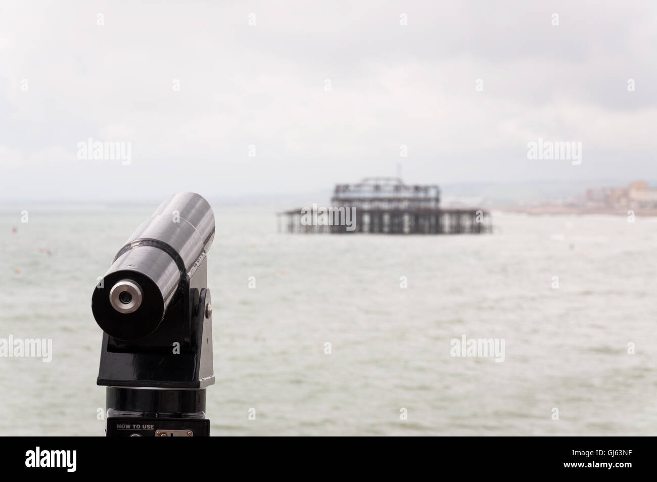Tourist telescope facing the old west pier in Brighton,East Sussex, UK