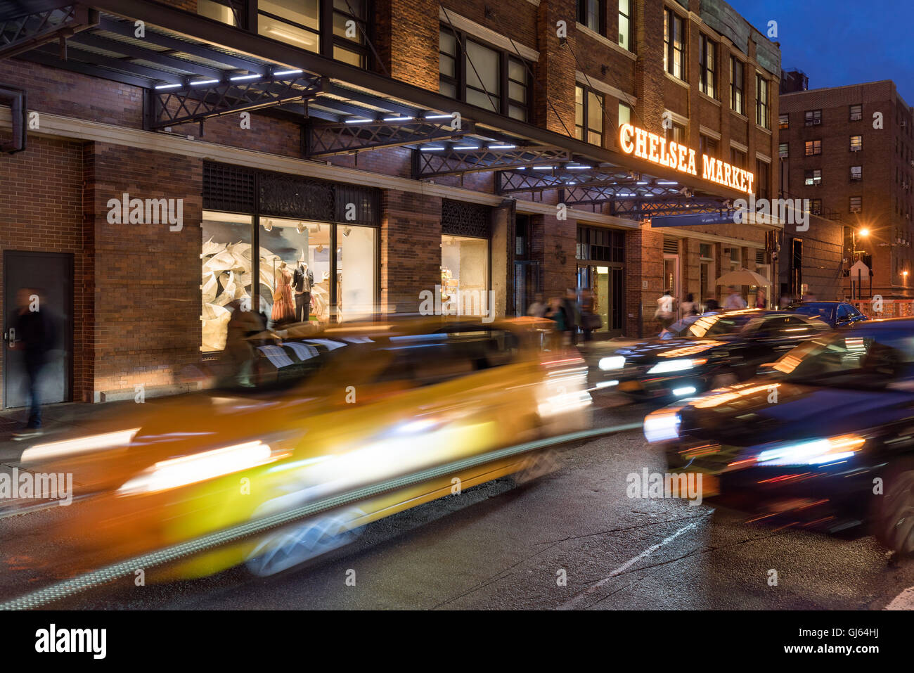 Chelsea Market entrance on 10th Avenue at dusk with traffic and car light trails. Chelsea, Manhattan, New York City, USA Stock Photo