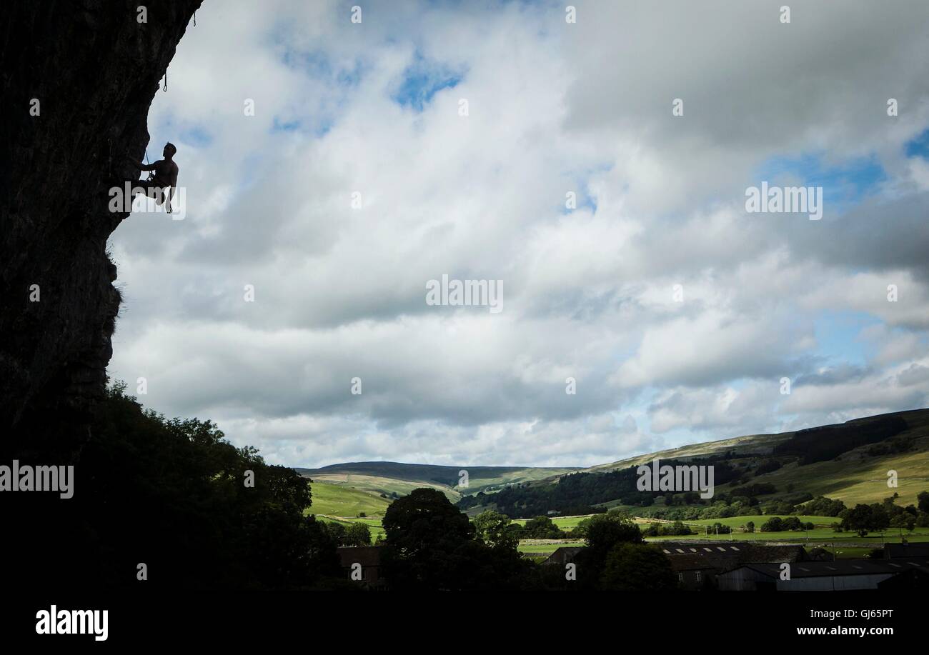 A rock climber on Kilnsey Crag, one of Yorkshire's 'Big Three' limestone rock face, in the Yorkshire Dales National Park. Stock Photo