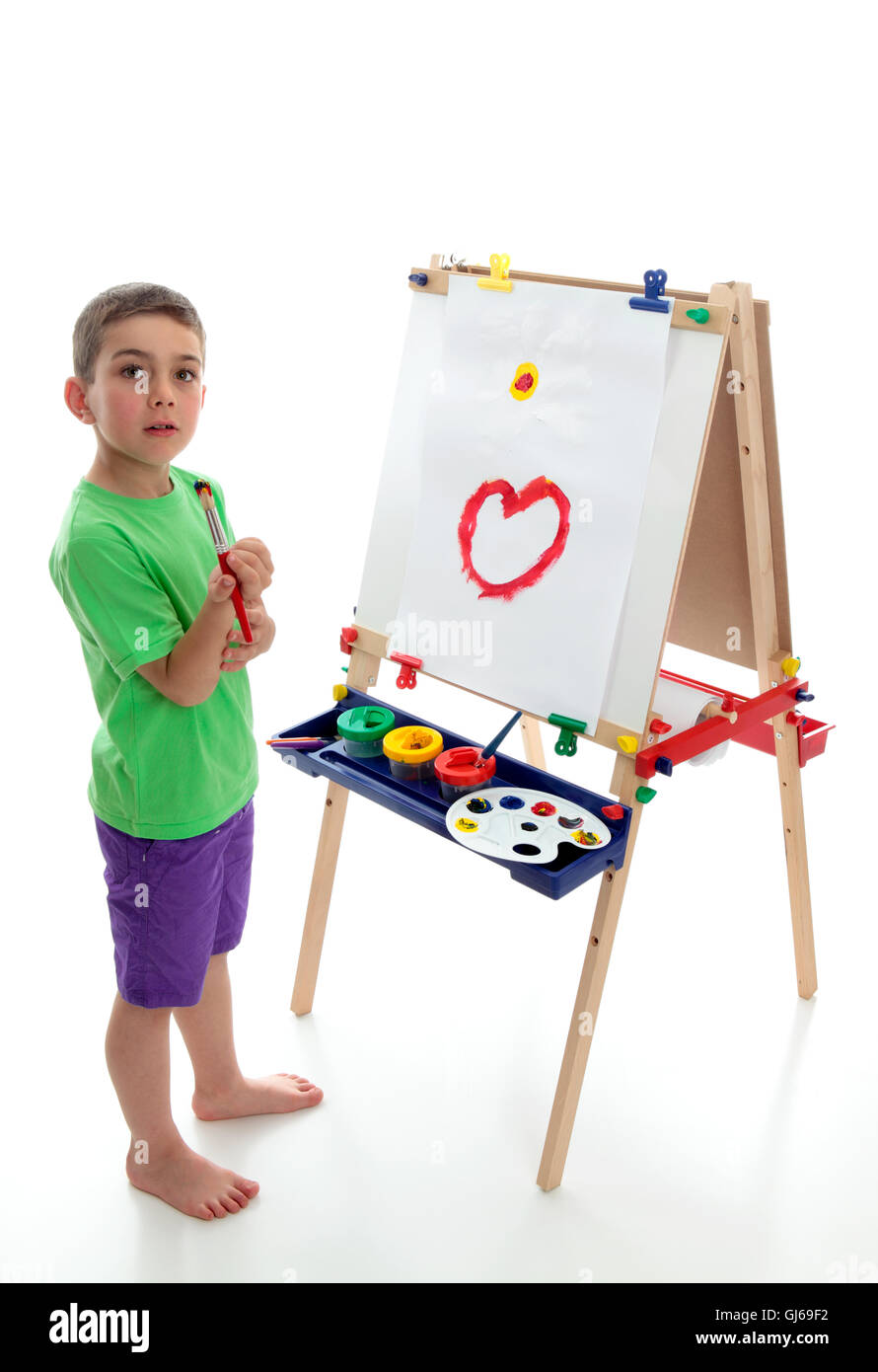 Young child standing at art easel Stock Photo