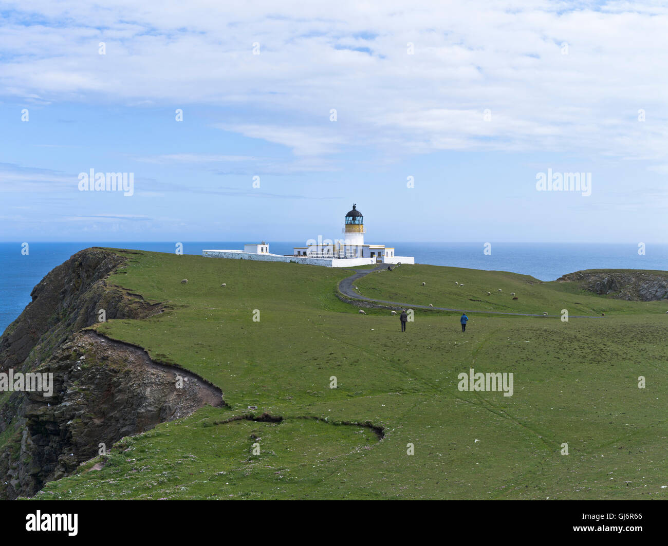 dh North Lighthouse FAIR ISLE SHETLAND Hiker couple walking cliff tops to lighthouse isles scotland people hikers Stock Photo