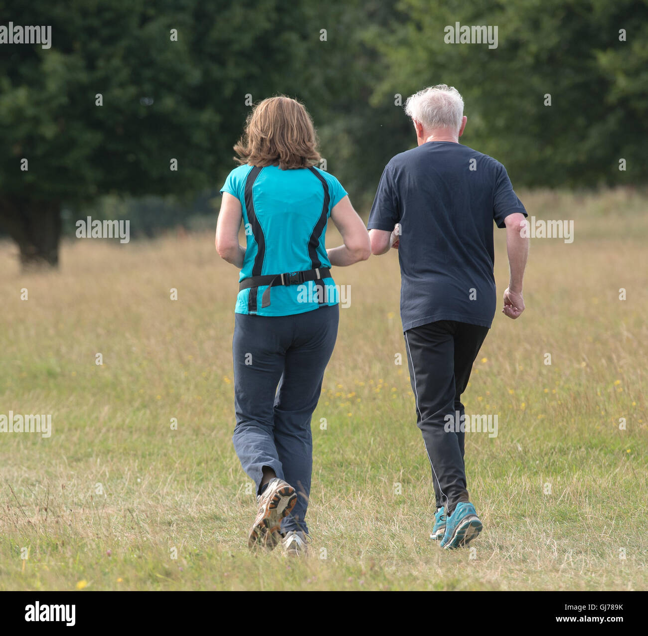 Older man and daughter on the park run Stock Photo
