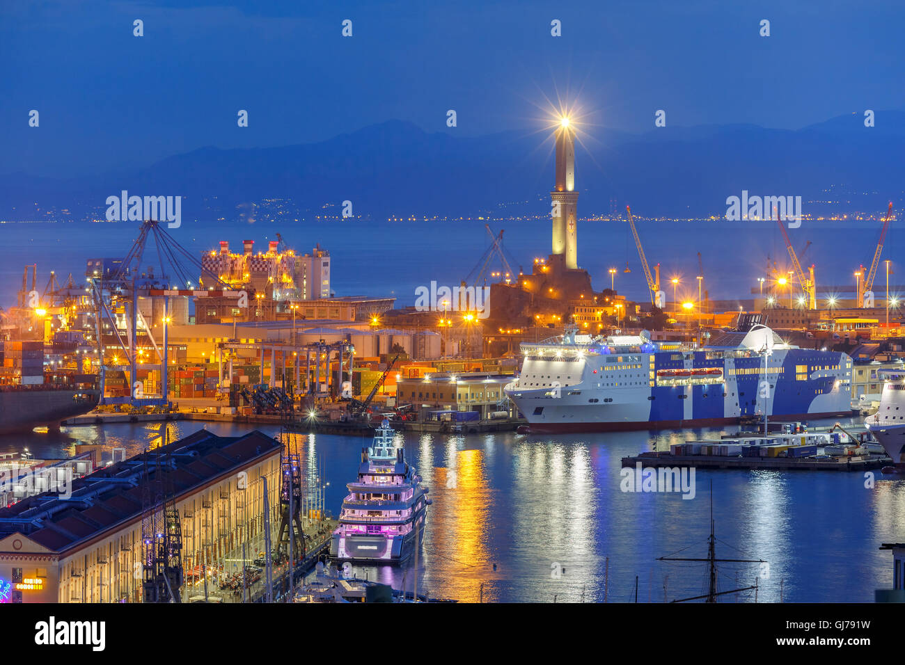 Old Lighthouse in port of Genoa at night, Italy. Stock Photo
