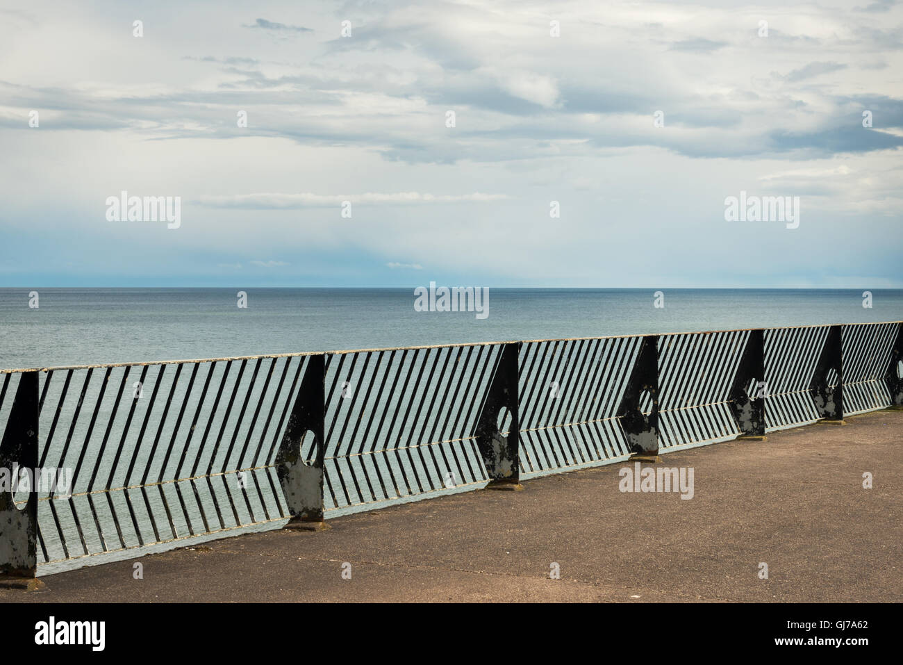Youghal seafront empty concrete platform deck with metal railings facing open sea Stock Photo