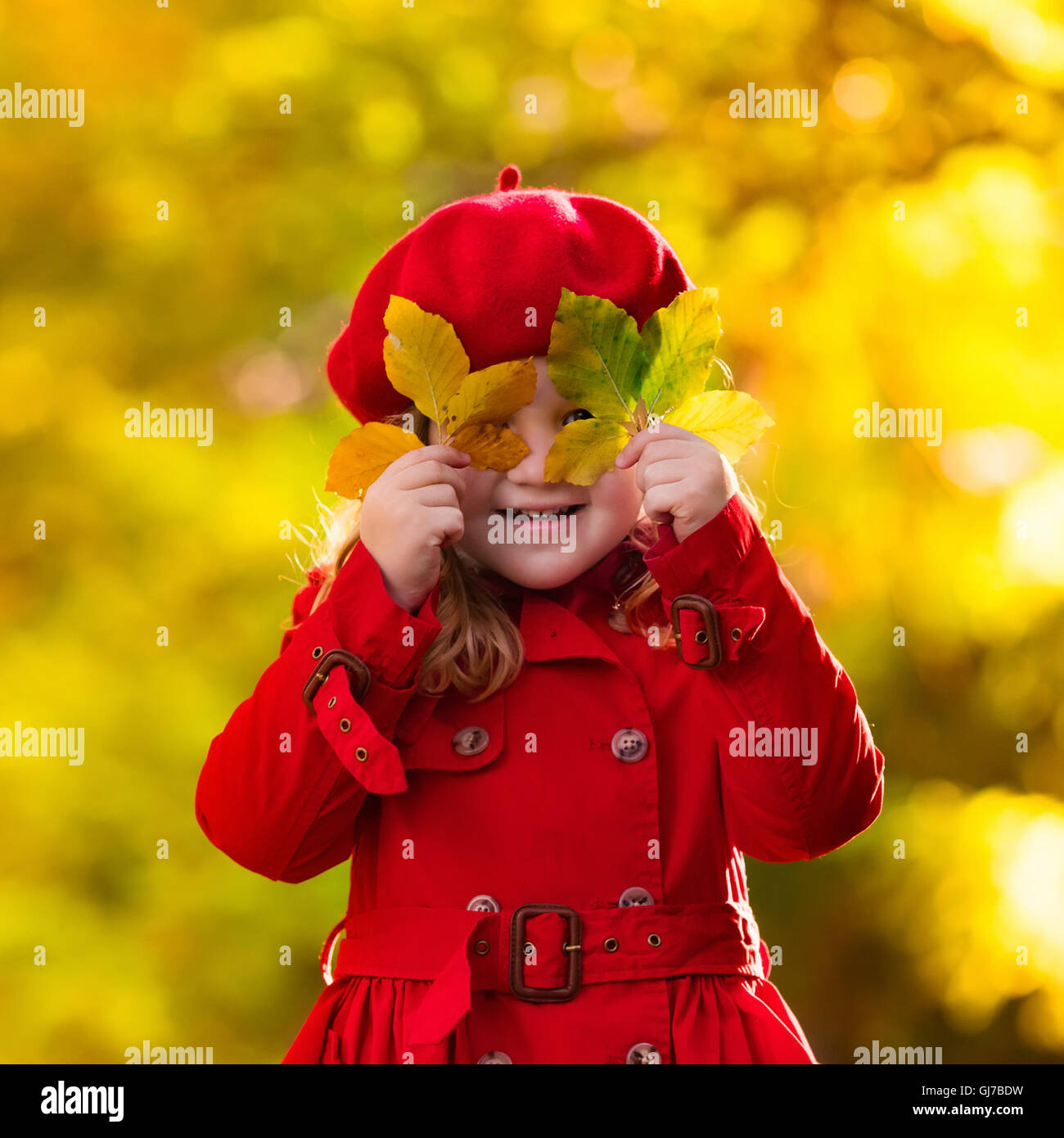 Happy little girl playing in beautiful autumn park on warm sunny fall ...