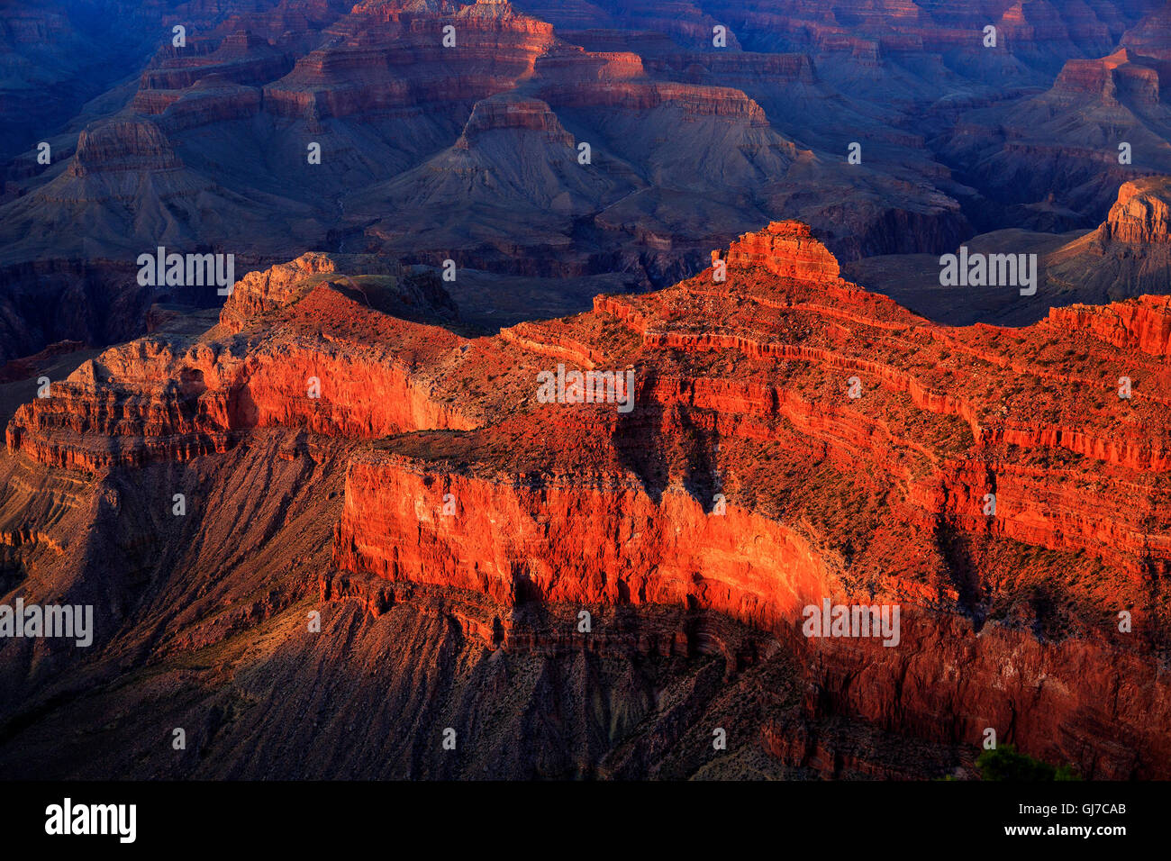 The setting sun lights up some red rock formations seen to the northeast from Mather Point, Grand Canyon National Park, Arizona Stock Photo