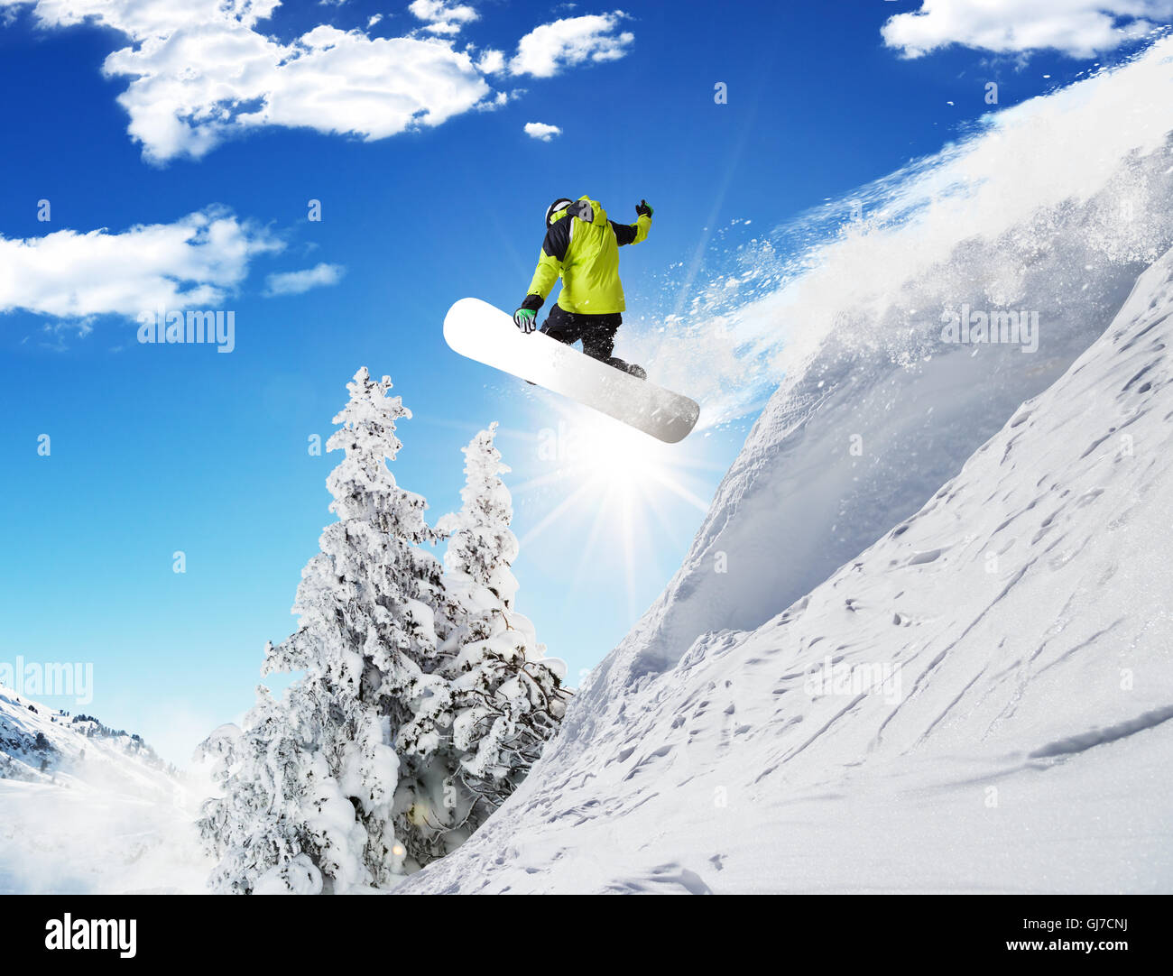 Snowboarder at jump in Alpine mountains in beautiful sunny day. Copyspace for text Stock Photo
