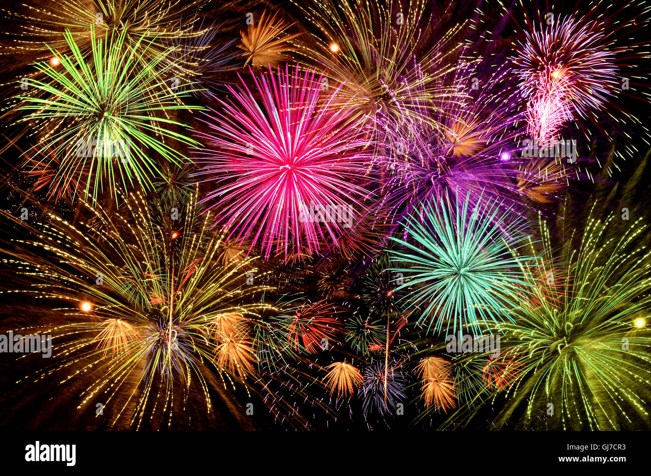 Colorful firework celebration on dark night sky background. Beautiful fireworks show on clear night sky. Stock Photo
