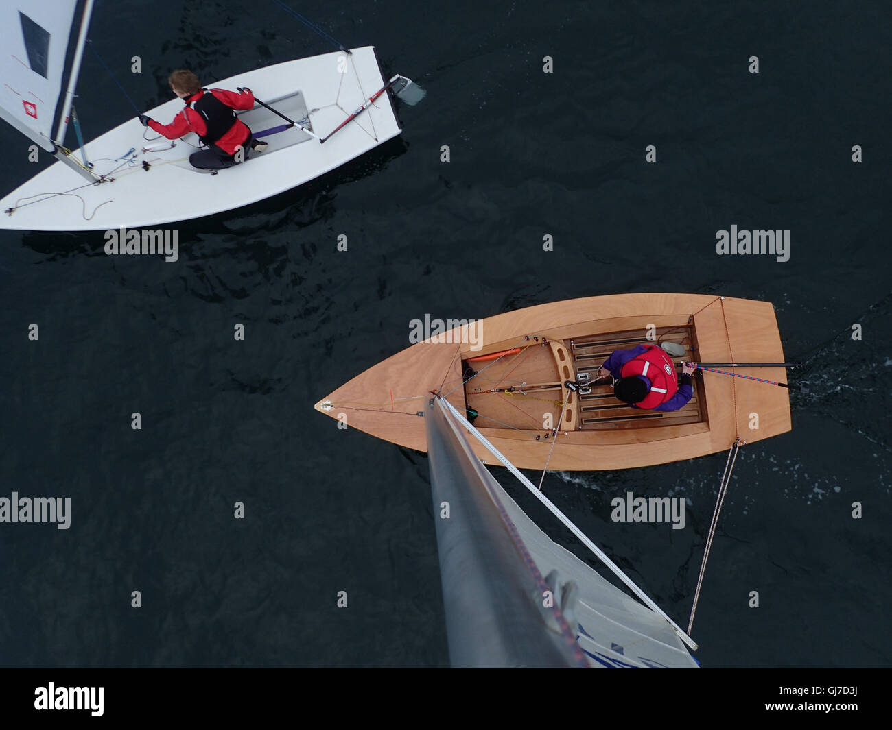 View downwards from top of mast of Streaker Class Sailing Dinghy, with male helm in his sixties Stock Photo