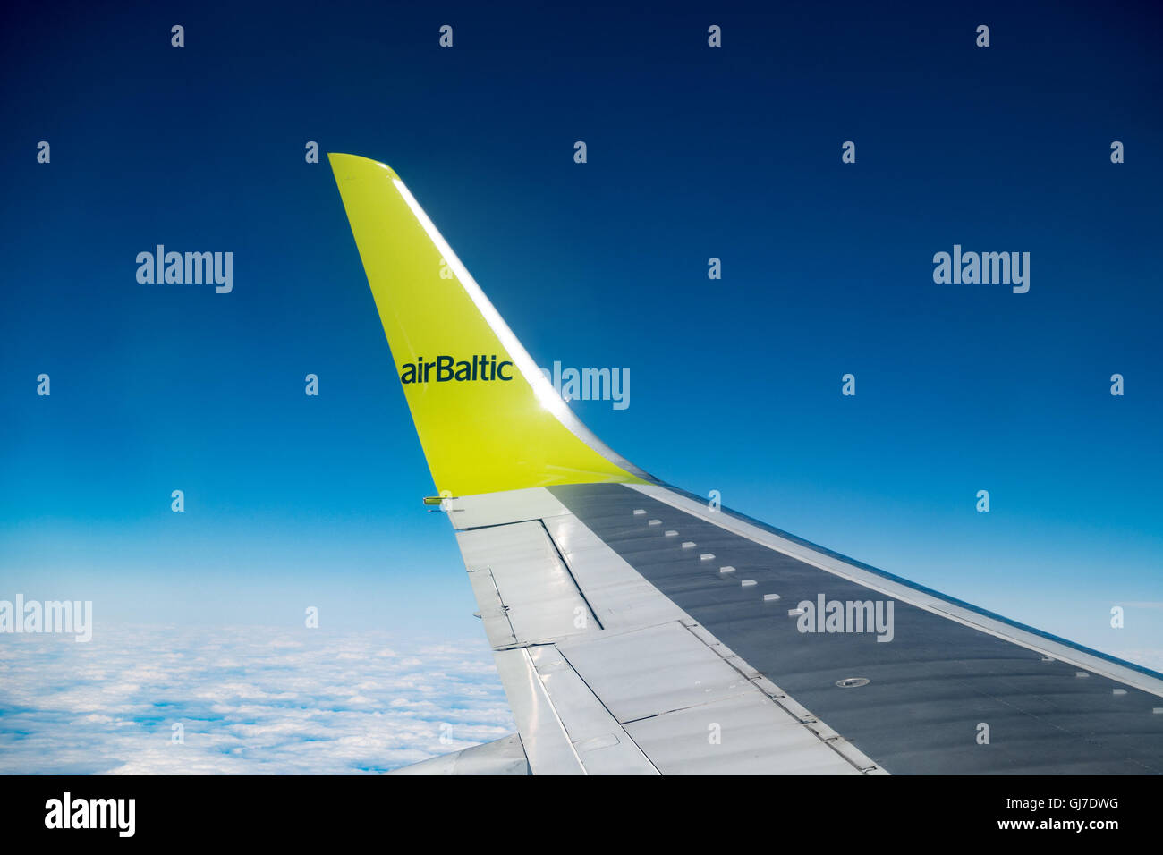 RIGA, LATVIA - MAY, 25, 2016: Aircraft wing,  Clouds skies above and below. AS Air Baltic Corporation,  is the Latvian flag carr Stock Photo