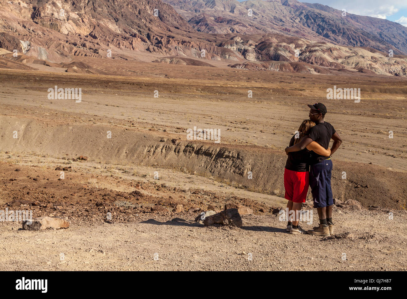 Interracial couple enjoying the view of the volcanic and sedimentary hills near Artist's Palette, Death Valley National Park, Ca Stock Photo