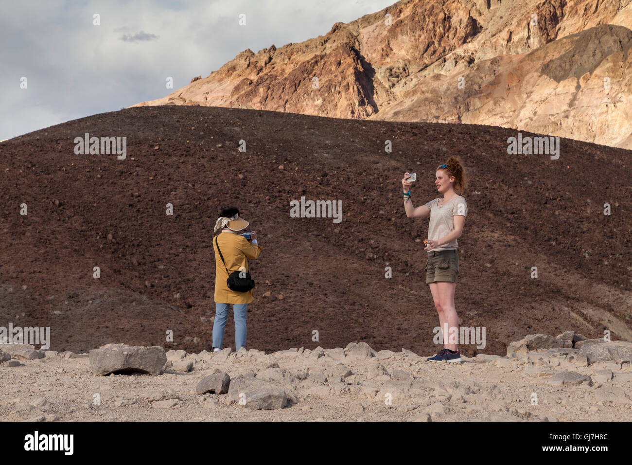 Woman taking selfies by the volcanic and sedimentary hills near Artist's Palette in Death Valley National Park, California, USA Stock Photo