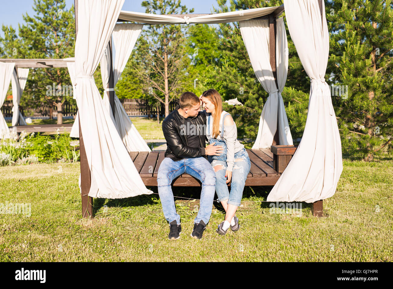 Happy pregnant woman and her husband in the park Stock Photo - Alamy