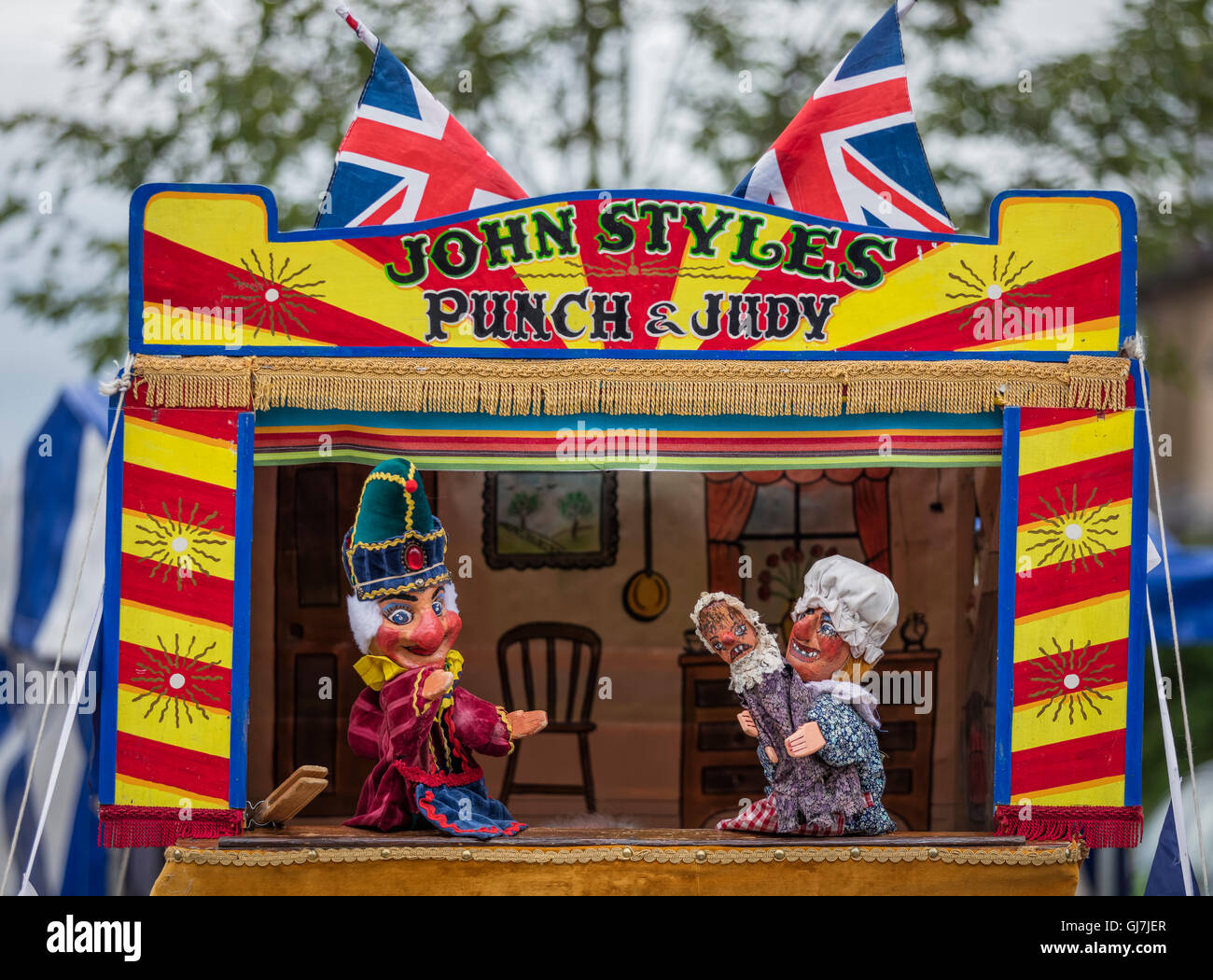 Mr Punch with Judy holding the baby in front of a Punch and Judy puppet