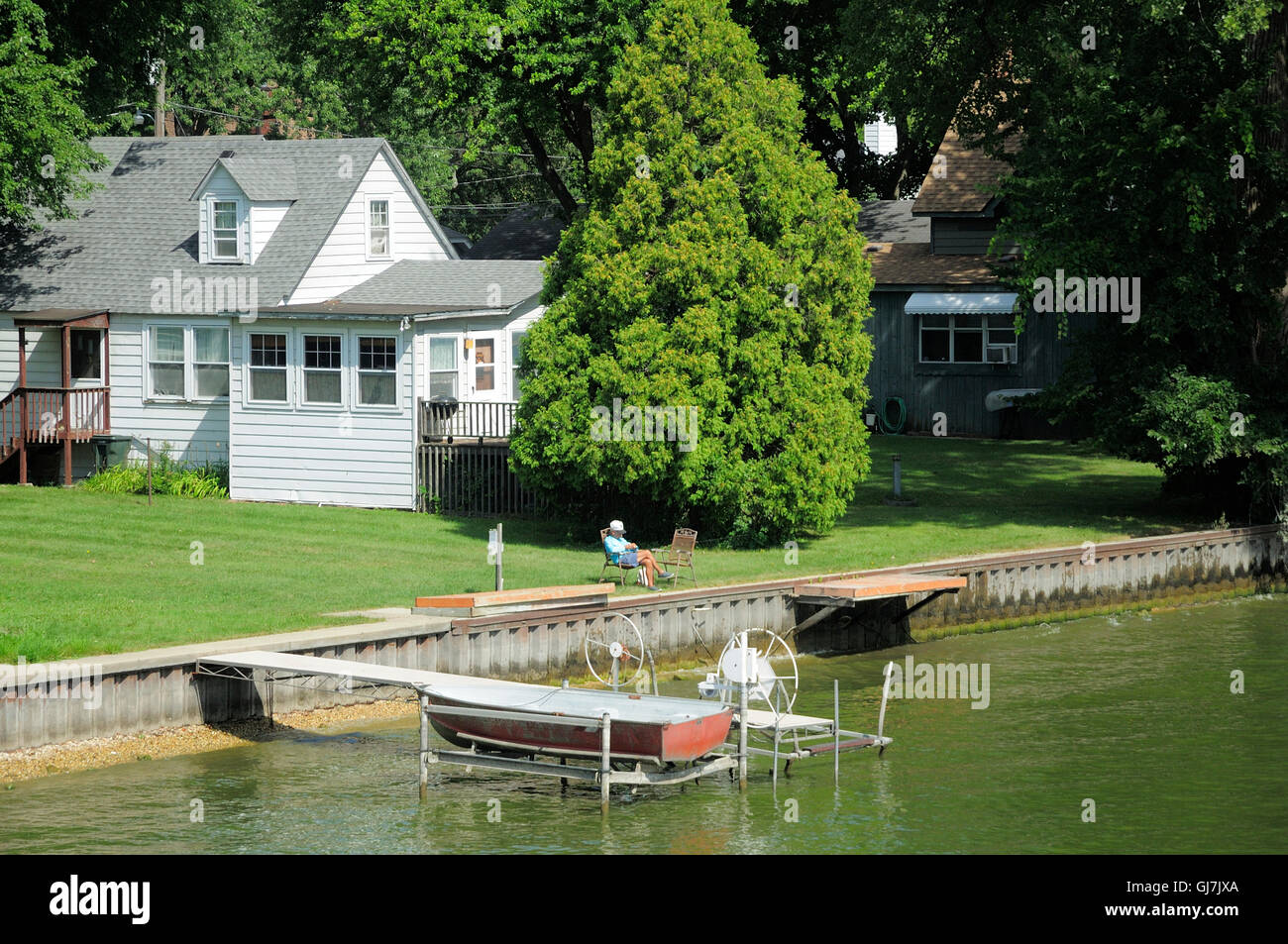 Old man enjoying view of river from his riverfront cottage. Stock Photo