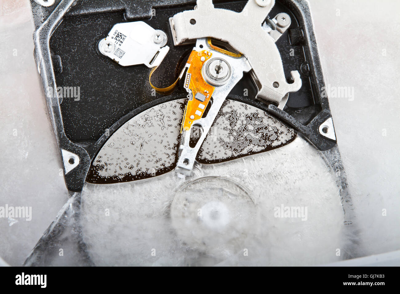 Close up of a hard drive covered in frost and half submerged in ice Stock Photo