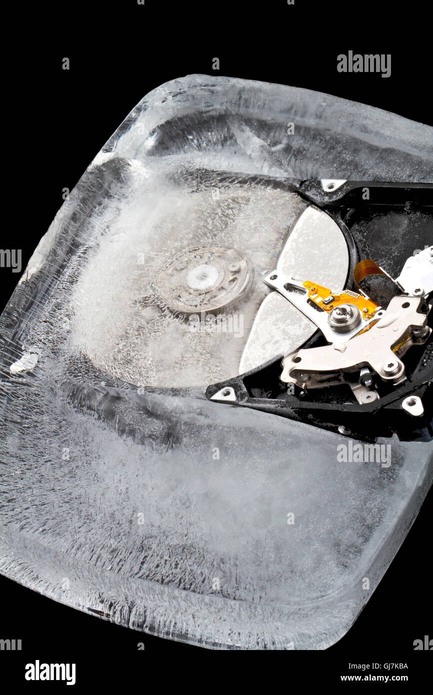 Hard drive frozen in an ice block on a black background Stock Photo