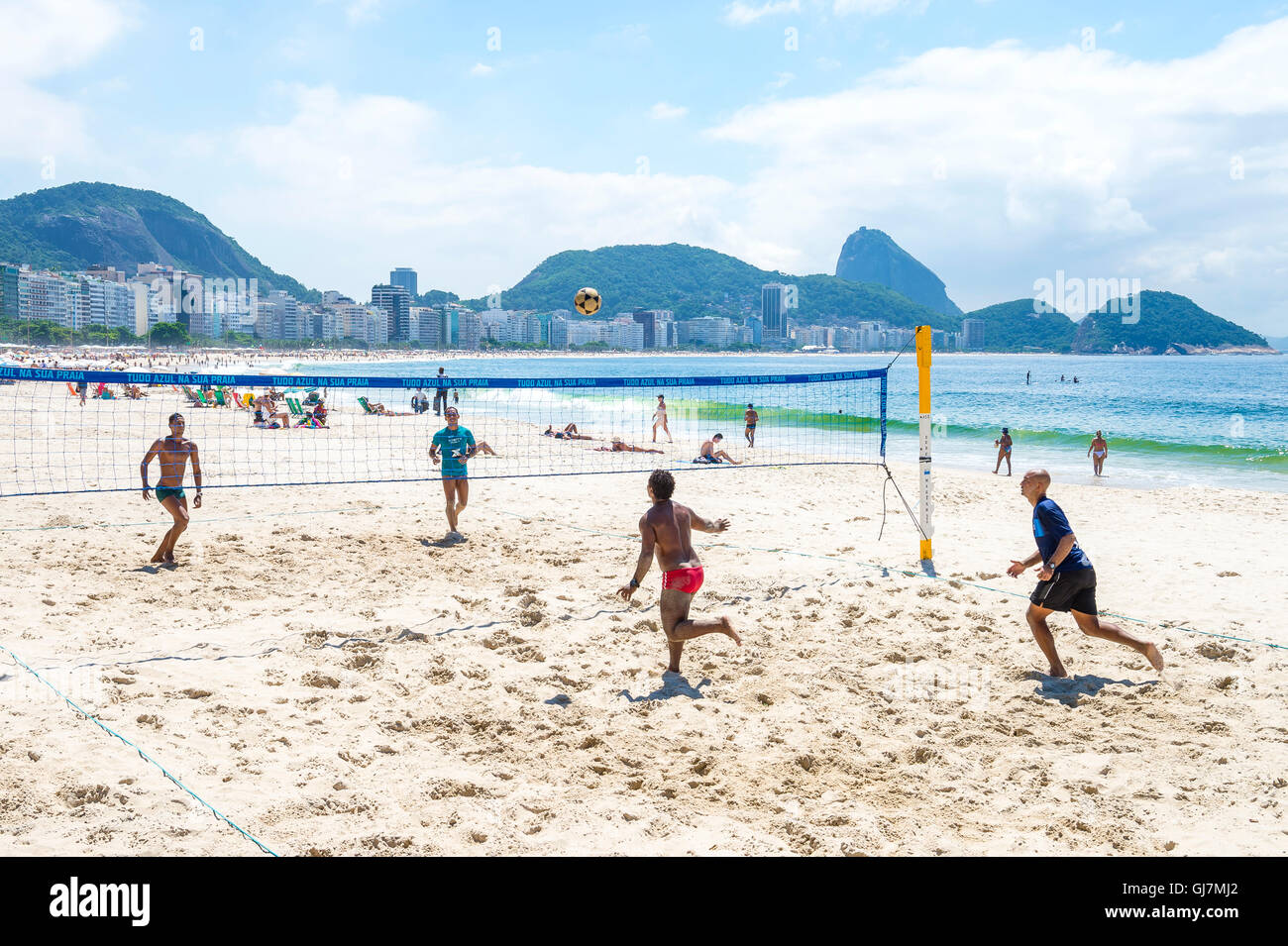 RIO DE JANEIRO - MARCH 15, 2016: Carioca Brazilian men play a game of futevôlei (footvolley, combining football and volleyball). Stock Photo