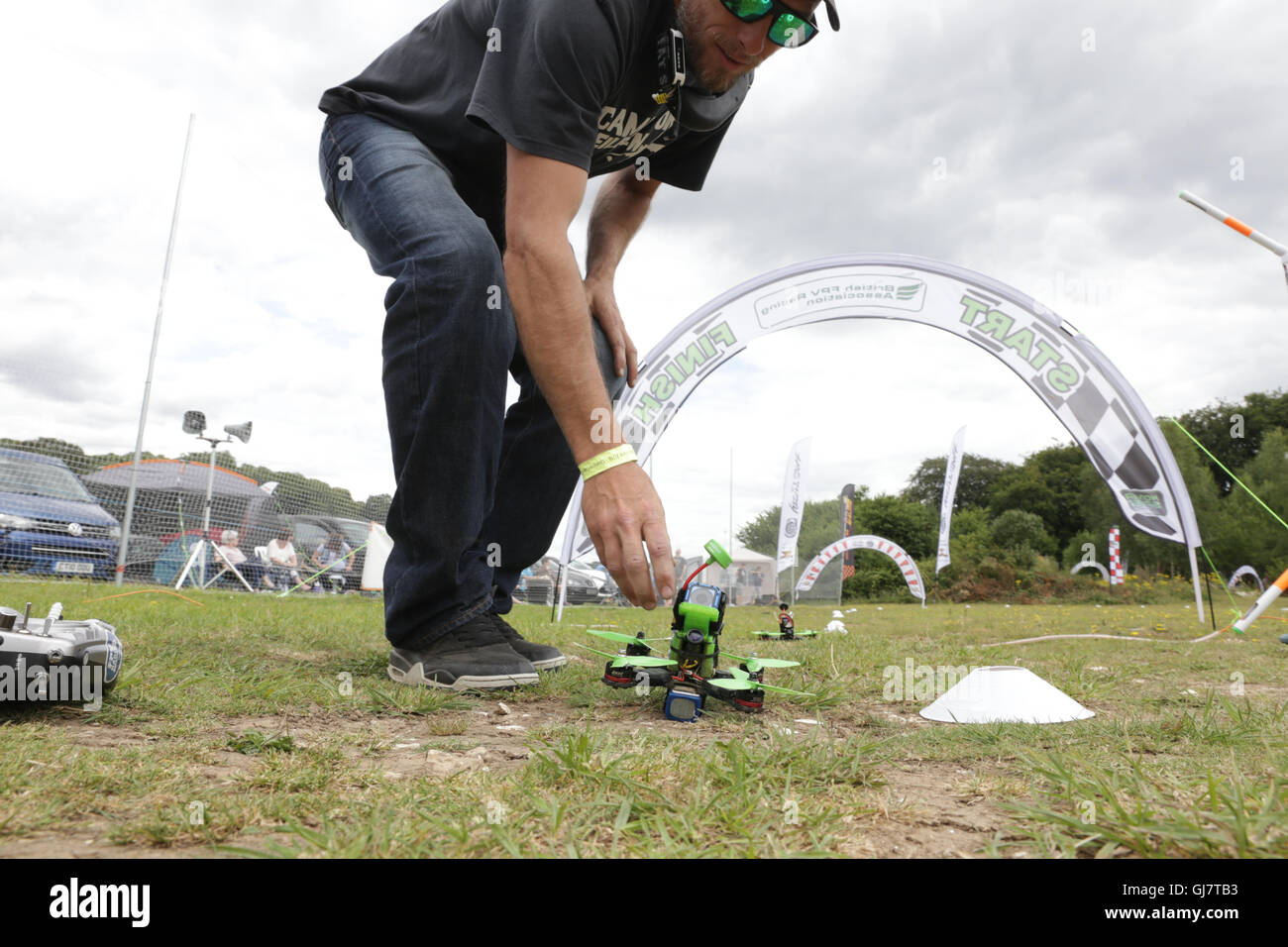 Drone Racing Queen's Cup 2016.  A drone racer pilot places a drone at thestart line prior to a race. Stock Photo