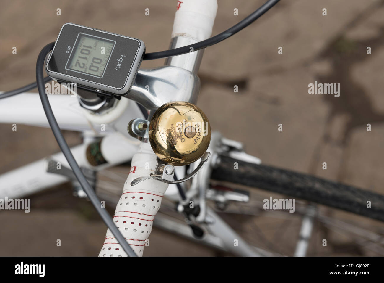 Old tech meets new tech on bike handlebars at a vintage cycling event. Stock Photo