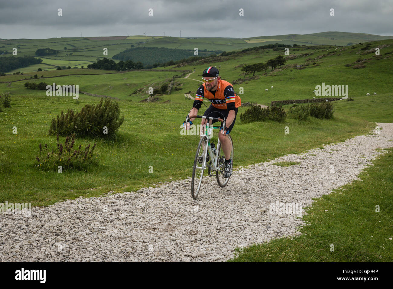 Vintage cyclists riding the gravel road to the Ulverston lighthouse during the L'Ancienne vintage cycling event based on Cumbria Stock Photo