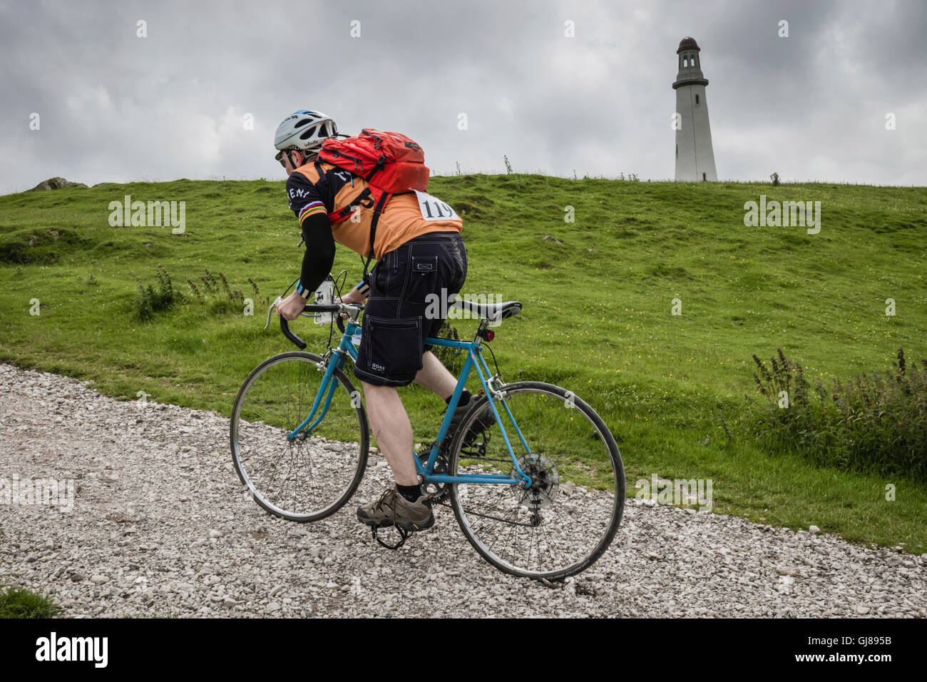 Vintage cyclists riding the gravel road to the Ulverston lighthouse during the L'Ancienne vintage cycling event based on Cumbria Stock Photo