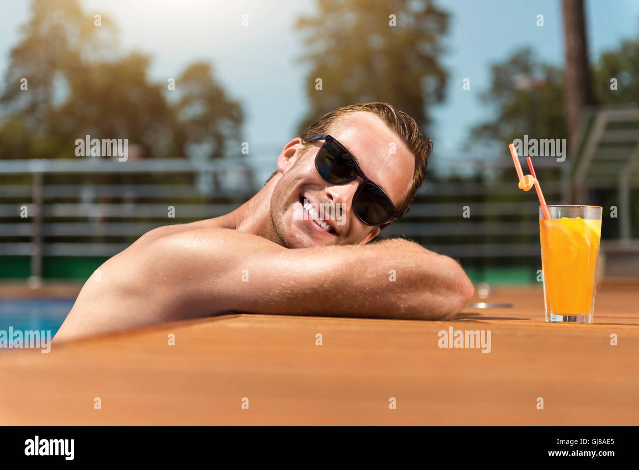 Positive smiling man relaxing in the swimming pool Stock Photo - Alamy