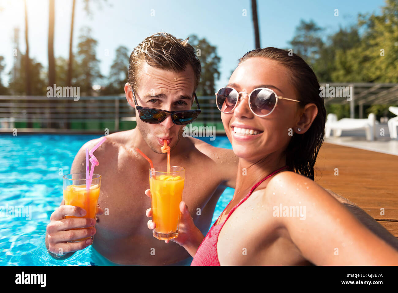 Positive couple resting in a swimming pool Stock Photo