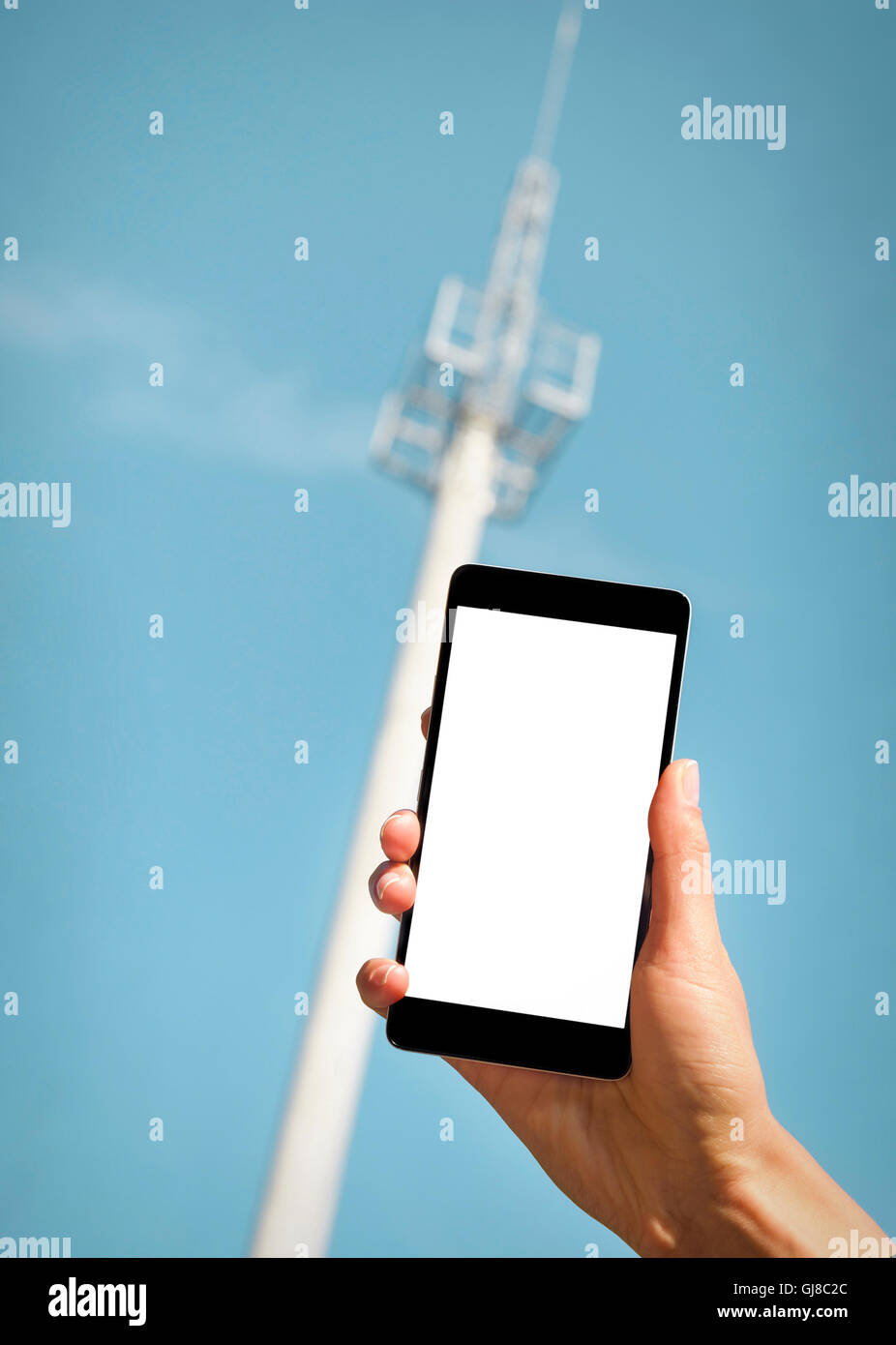 Smartphone in hand on background tower mobile operator Stock Photo Alamy