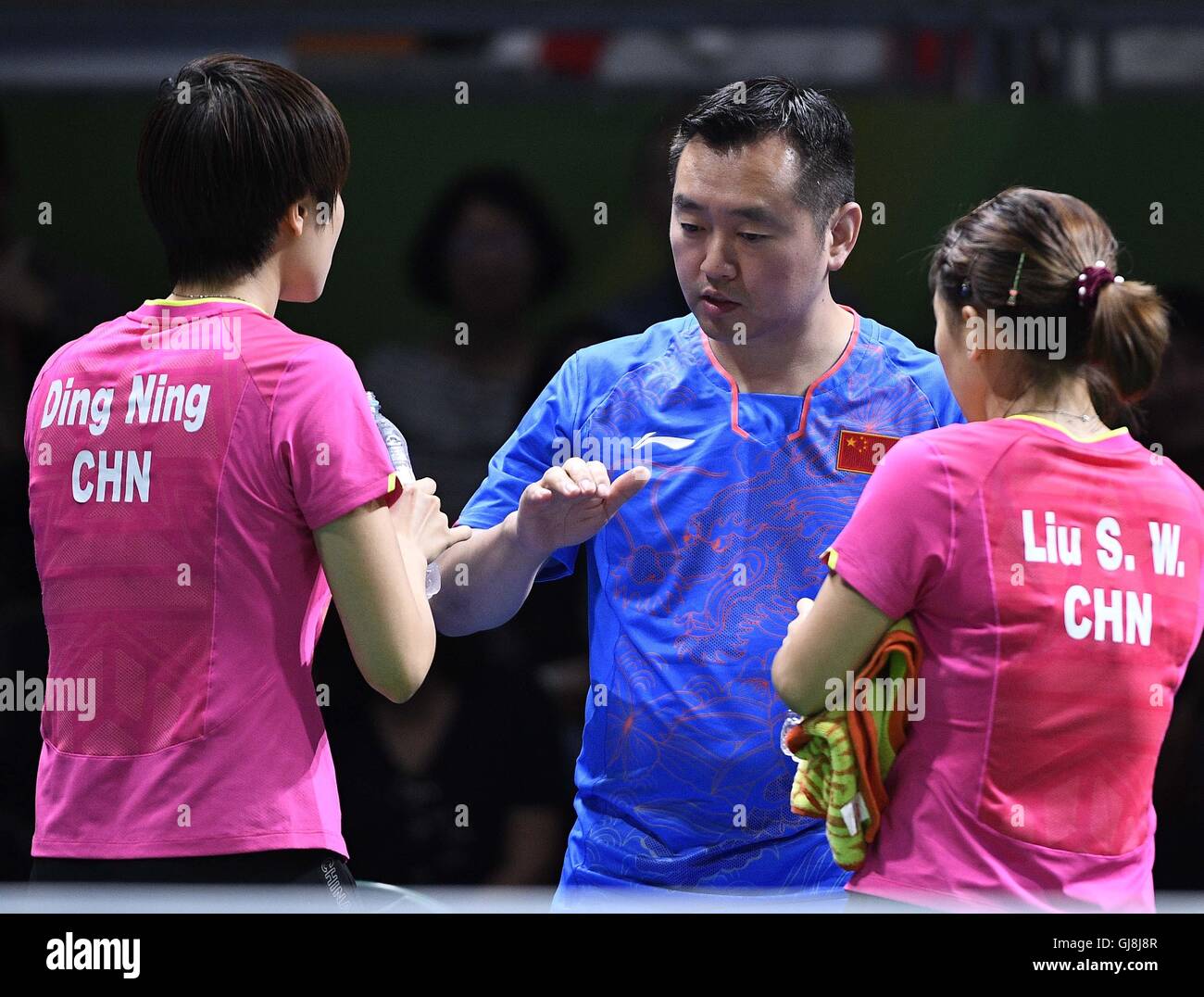 Rio De Janeiro, Brazil. 13th Aug, 2016. China's coach Kong Linghui (C) communicates with Liu Shiwen (R) and Ding Ning during the women's team quarterfinal of Table Tennis against the Democratic People's Republic of Korea (DPRK) at the 2016 Rio Olympic Games in Rio de Janeiro, Brazil, on Aug. 13, 2016. China won 3-0. Credit:  Wang Peng/Xinhua/Alamy Live News Stock Photo