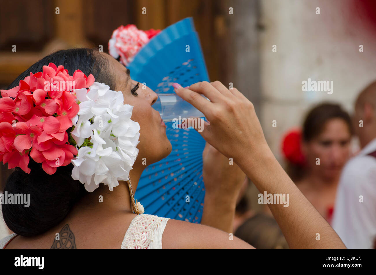 Malaga, Andalusia, Spain. 13th Aug, 2016. Beautiful Spanish woman drinking sherry during start of Annual Feria of Malaga, Southern Spain's biggest summer fair starts. The feria celebrations. Credit:  Perry van Munster/Alamy Live News Stock Photo
