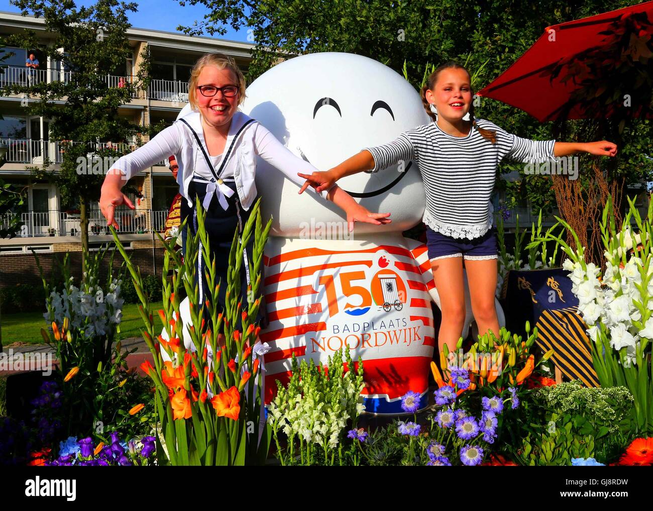 The Hague, Netherlands. 13th Aug, 2016. Two girls perform on a float during the Flower Parade in Noordwijk, the Netherlands, on Aug. 13, 2016. The annual Flower Parade since 1946 was held in Rijnsburg, Katwijk and Noordwijk of the Nehterlands on Saturday. Credit:  Gong Bing/Xinhua/Alamy Live News Stock Photo