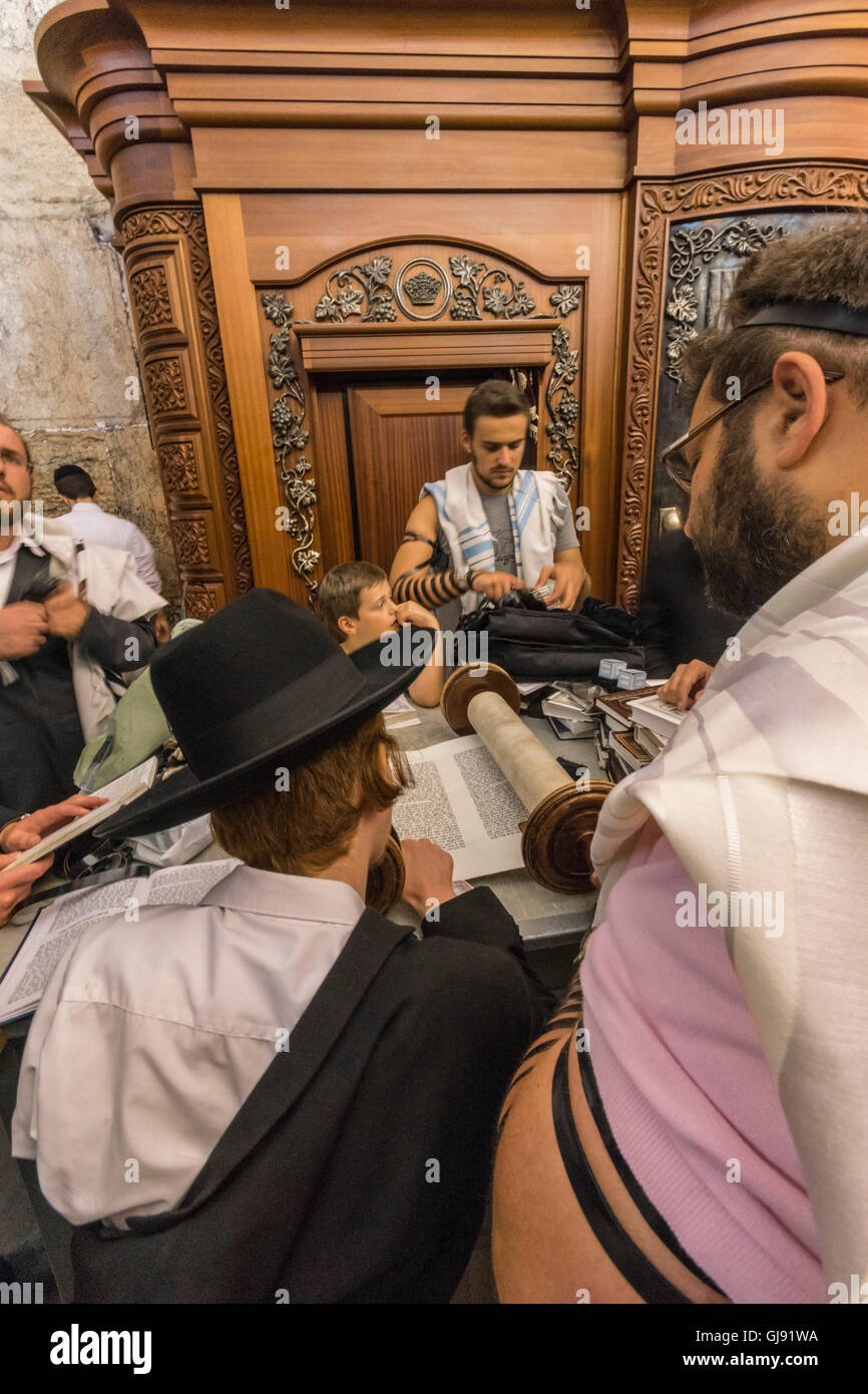 Jerusalem, Israel. 14th Aug, 2016. Observant Jews read the Torah (Holy Scriptures) in an underground section of the Western Wall in Jerusalem during the fast of 9th of Ab, when many Jews come to remember and mourn the destruction of the second temple by the Romans in 70 A.D. Credit:  Yagil Henkin/Alamy Live News Stock Photo