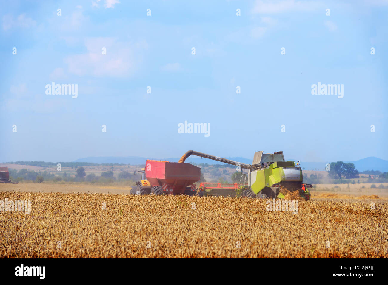 Amazing rural scene on autumn field with harvester Stock Photo