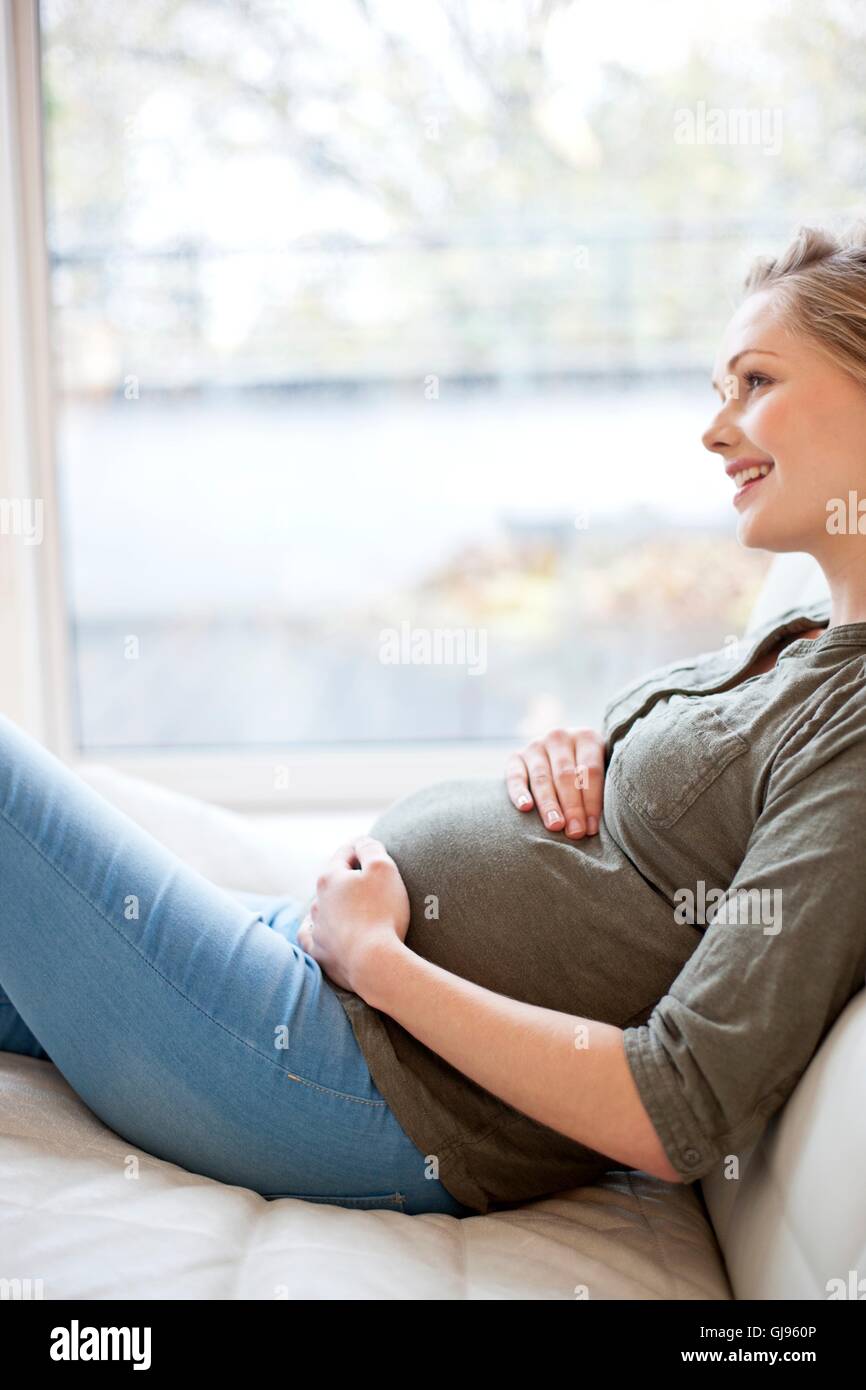 MODEL RELEASED. Pregnant woman touching her tummy. Stock Photo