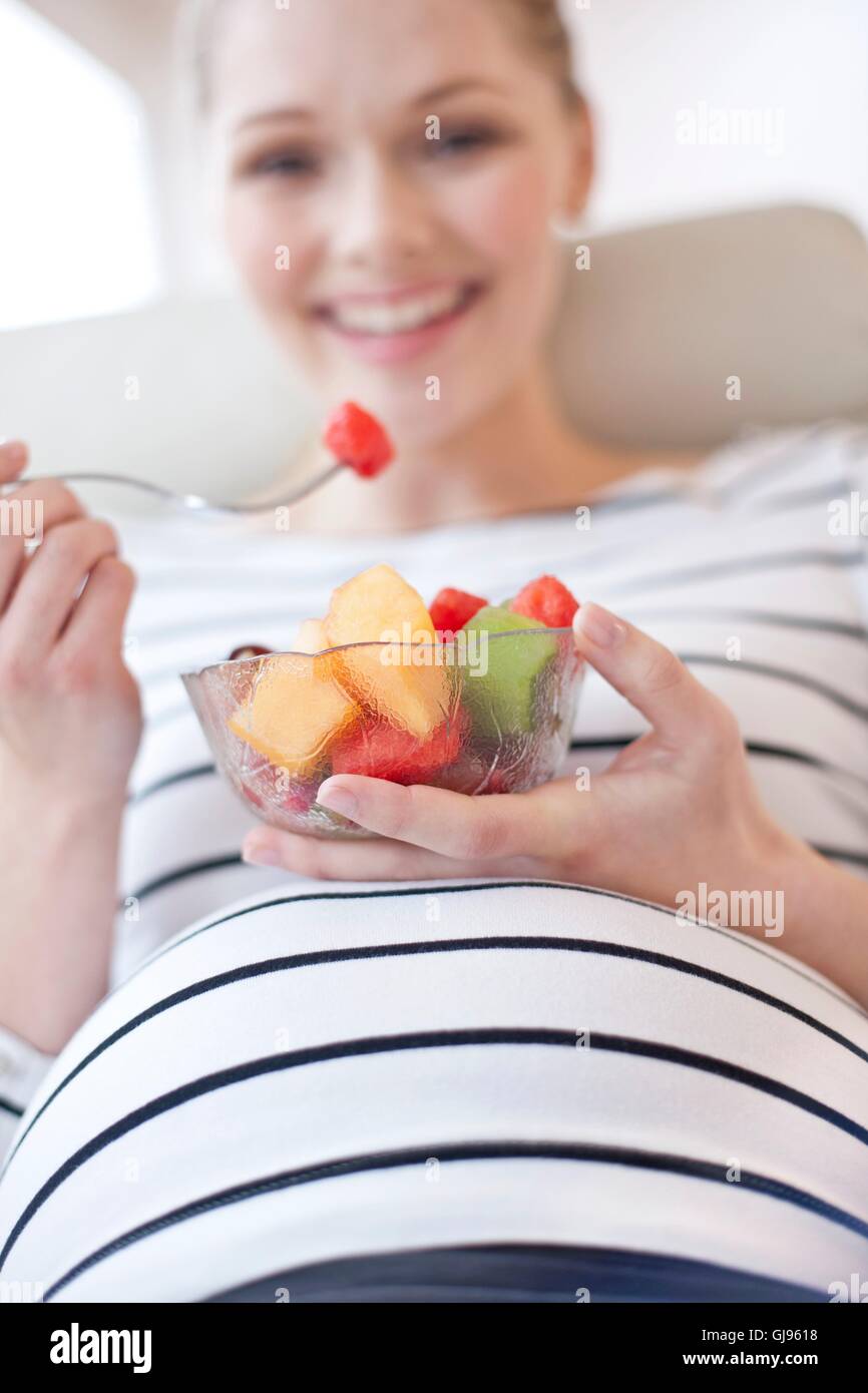 MODEL RELEASED. Pregnant woman eating fruit salad Stock Photo Alamy