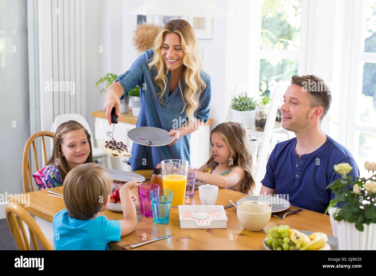 PROPERTY RELEASED. MODEL RELEASED. Family at dining table having a meal. Stock Photo