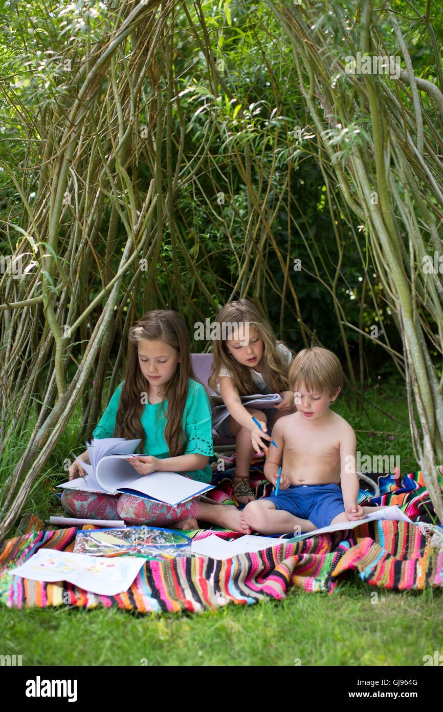 PROPERTY RELEASED. MODEL RELEASED. Children playing in a den in the garden. Stock Photo