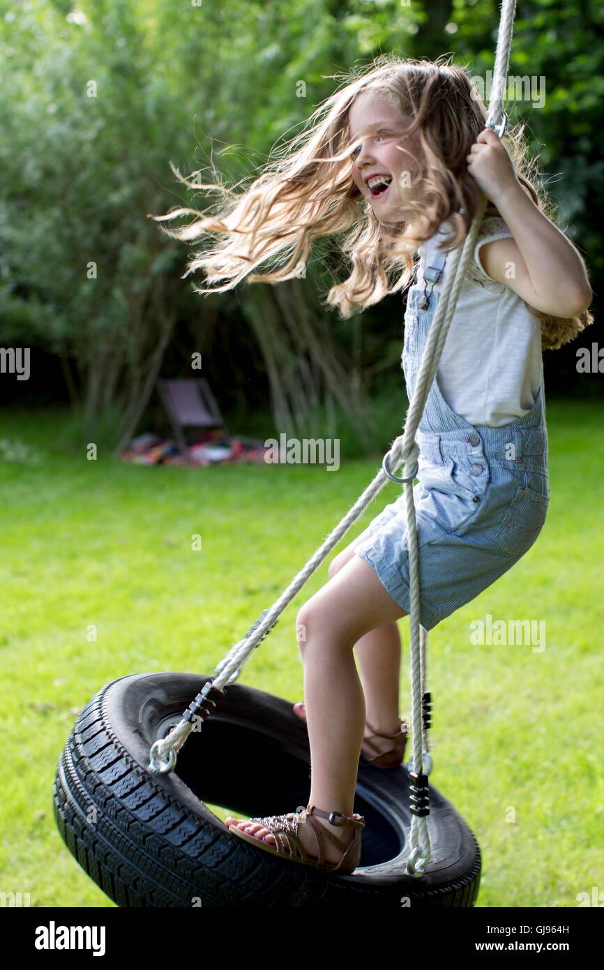 PROPERTY RELEASED. MODEL RELEASED. Girl playing on tyer swing. Stock Photo