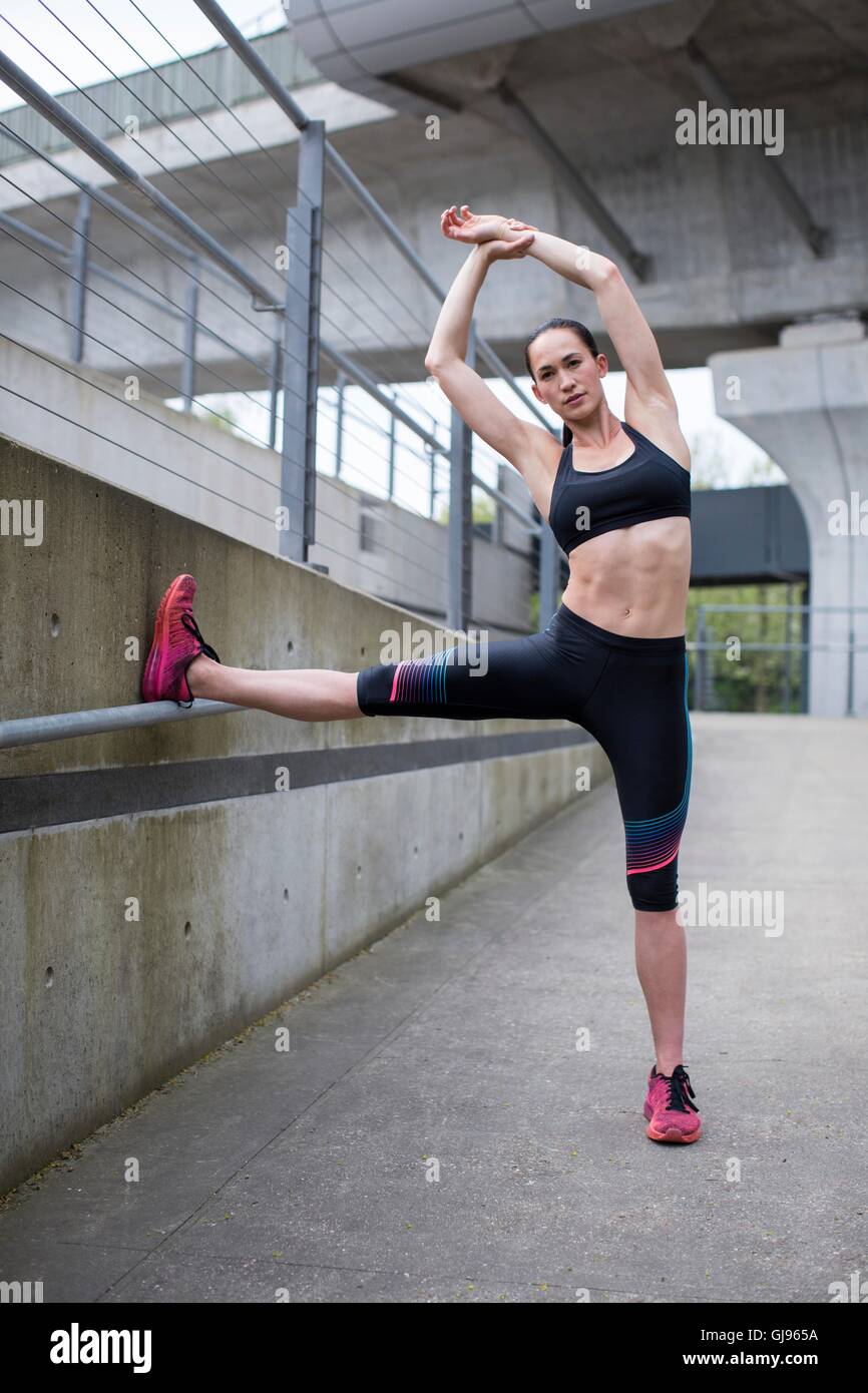 MODEL RELEASED. Young woman stretching in sports wear. Stock Photo