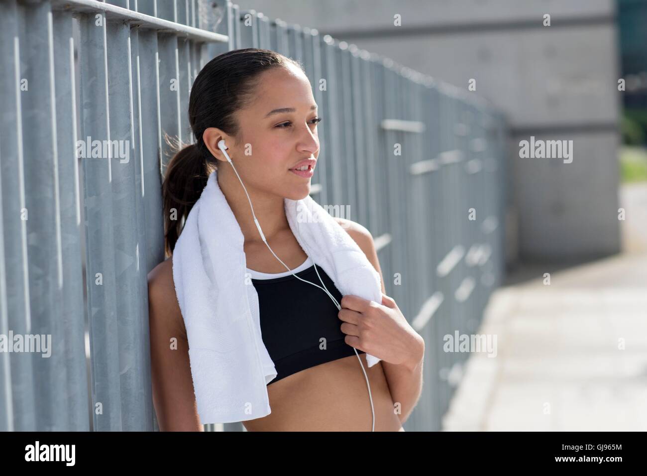 MODEL RELEASED. Young woman with towel around neck, smiling. Stock Photo